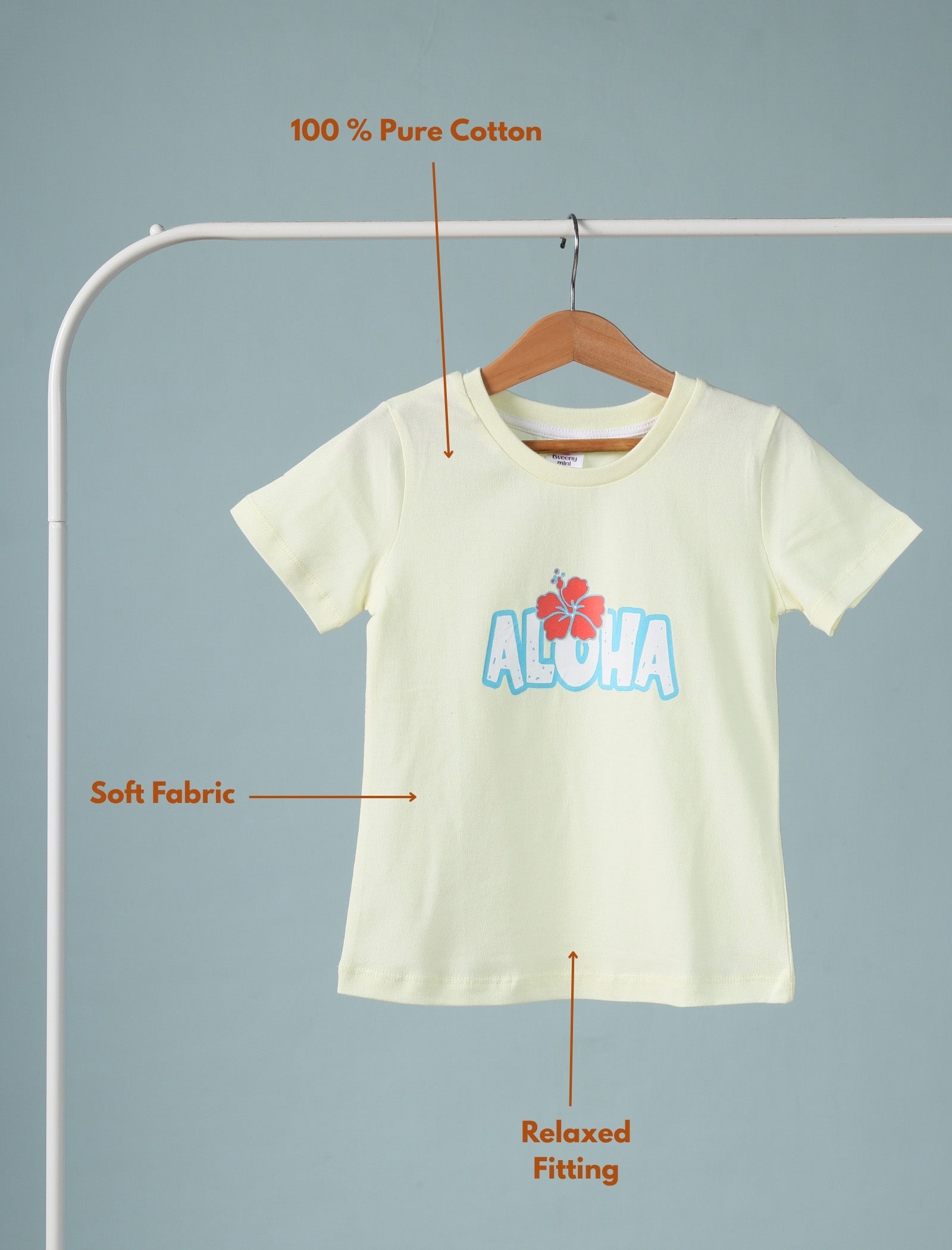 Lemon yellow t-shirt with 'Aloha' design on a hanger against a gray background