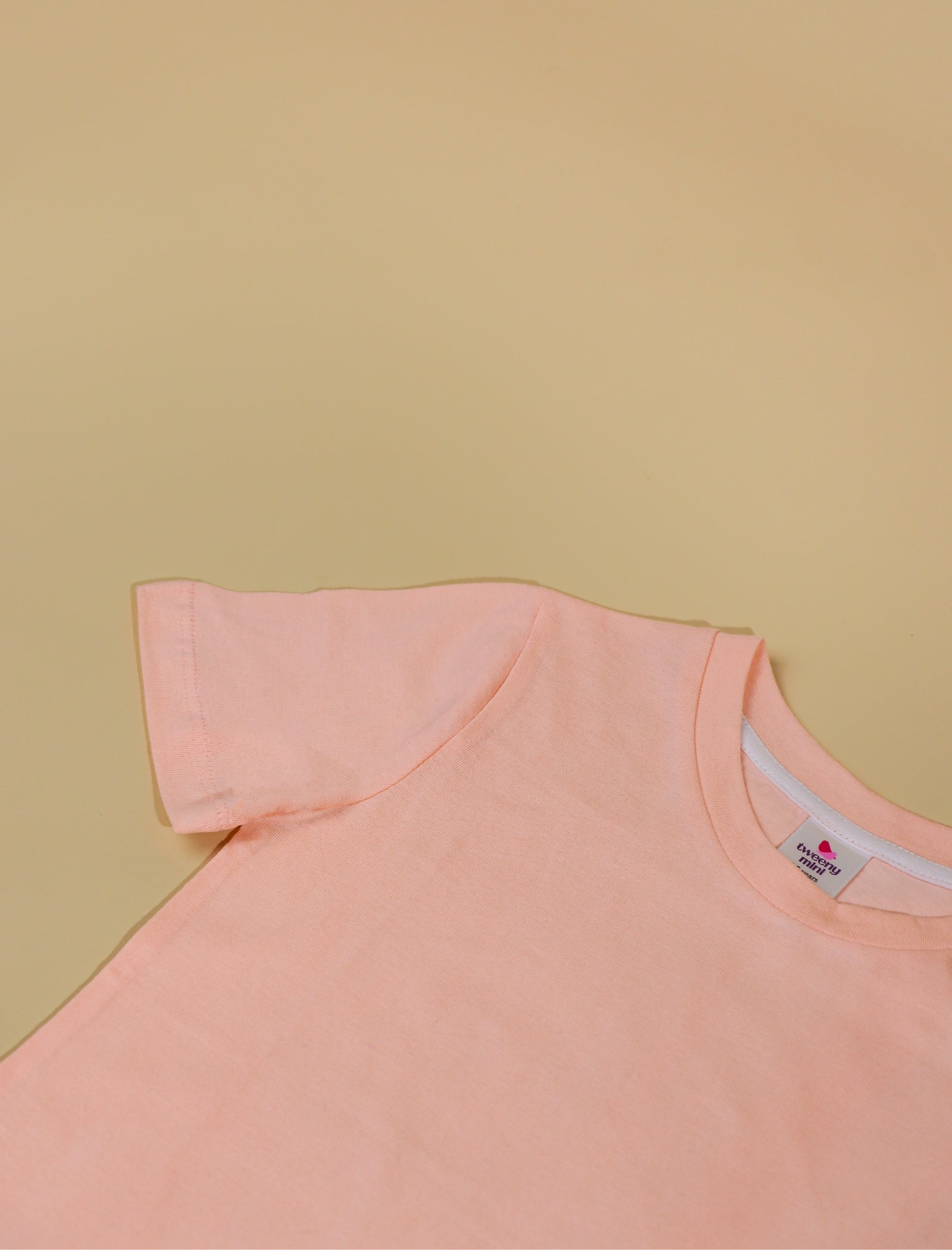 peach sleeveless top on a beige background
