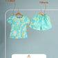 Tie-dye t-shirt and shorts set on hangers with washing instructions on a gray background