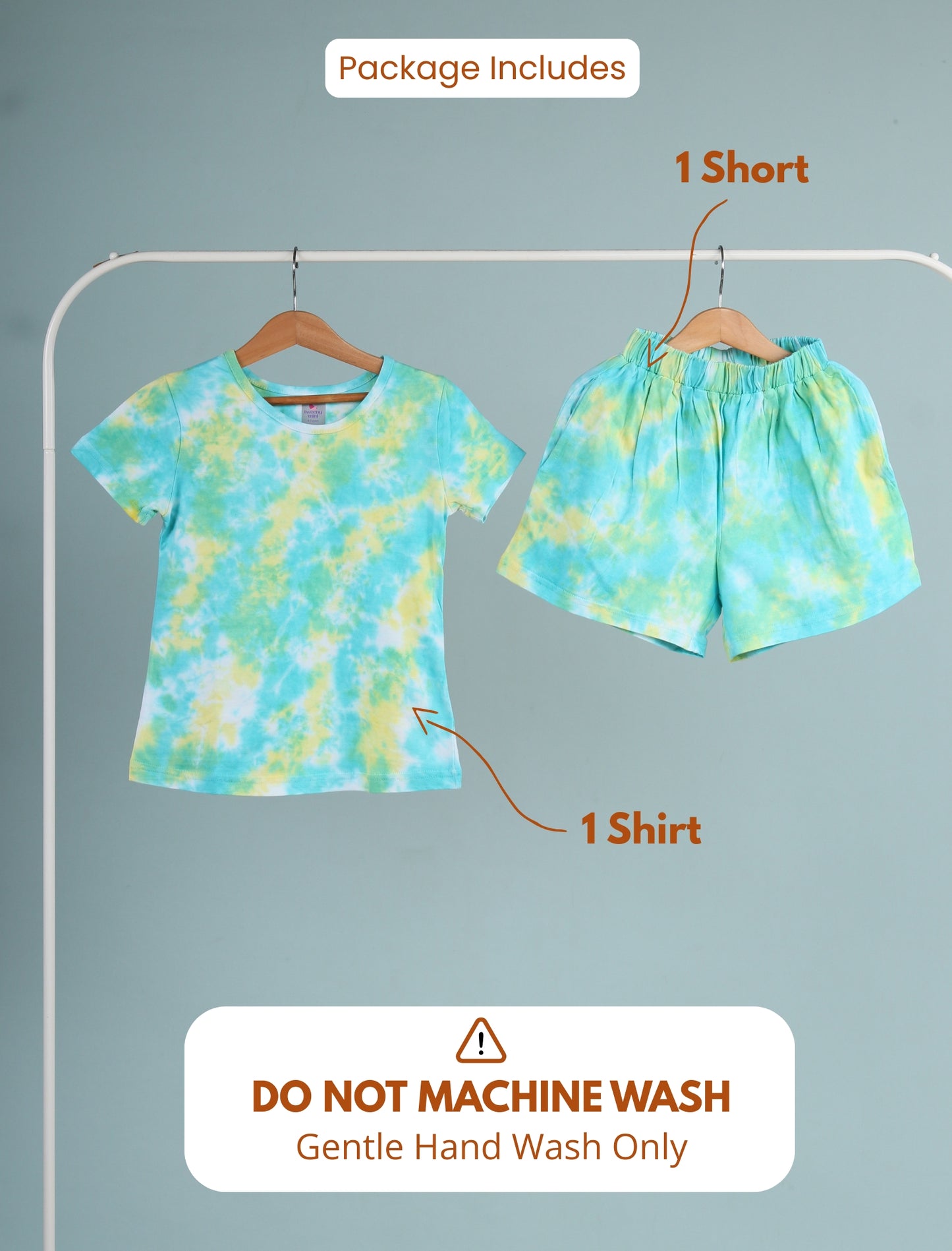 Tie-dye shirt and shorts set on hangers with washing instructions on a gray background