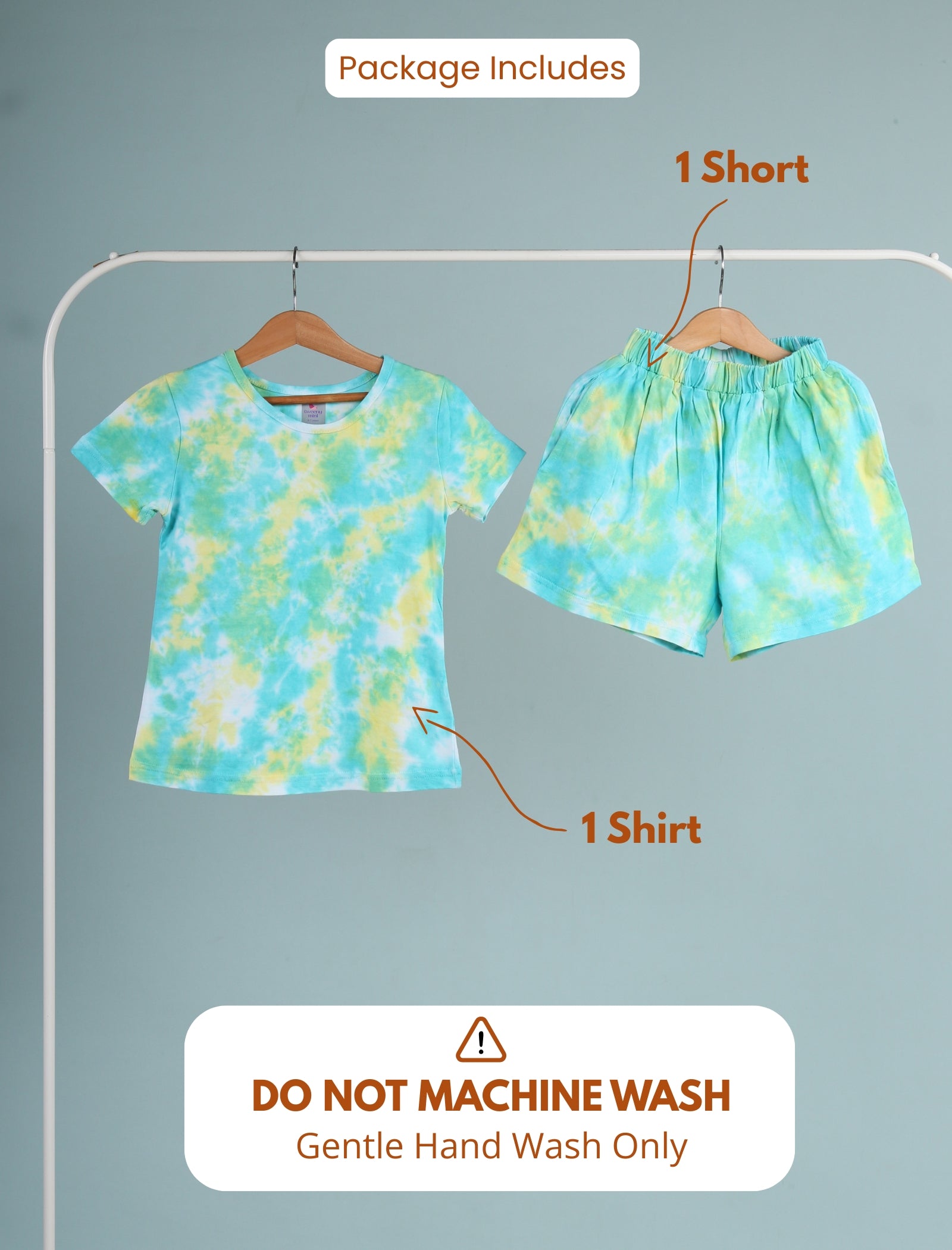 Tie-dye shirt and shorts set on hangers with washing instructions on a gray background