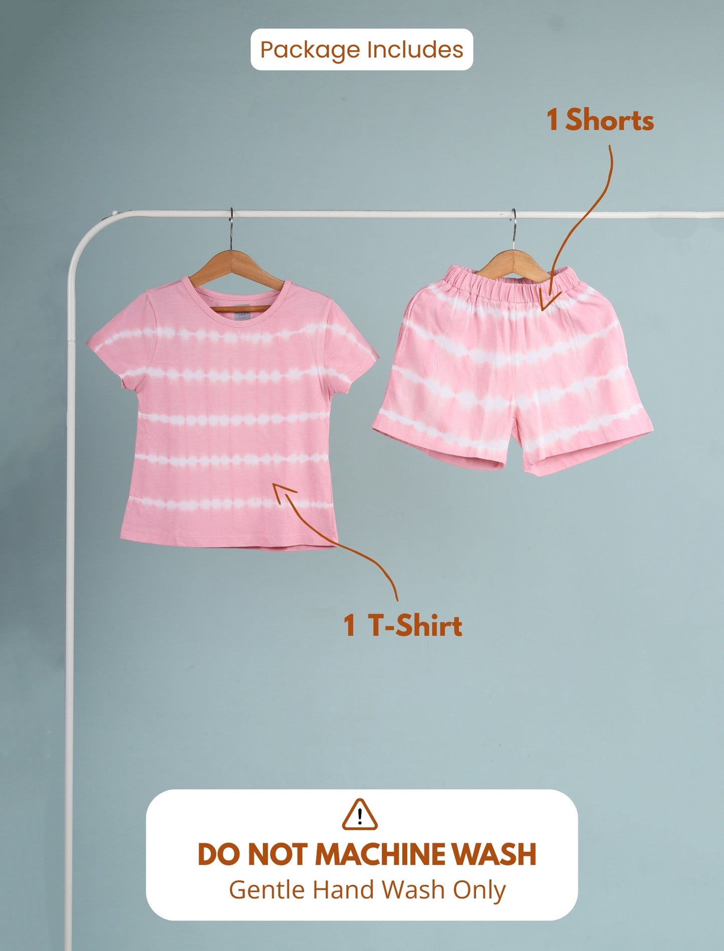 Pink t-shirt and shorts on hangers with text indicating package contents and washing instructions.