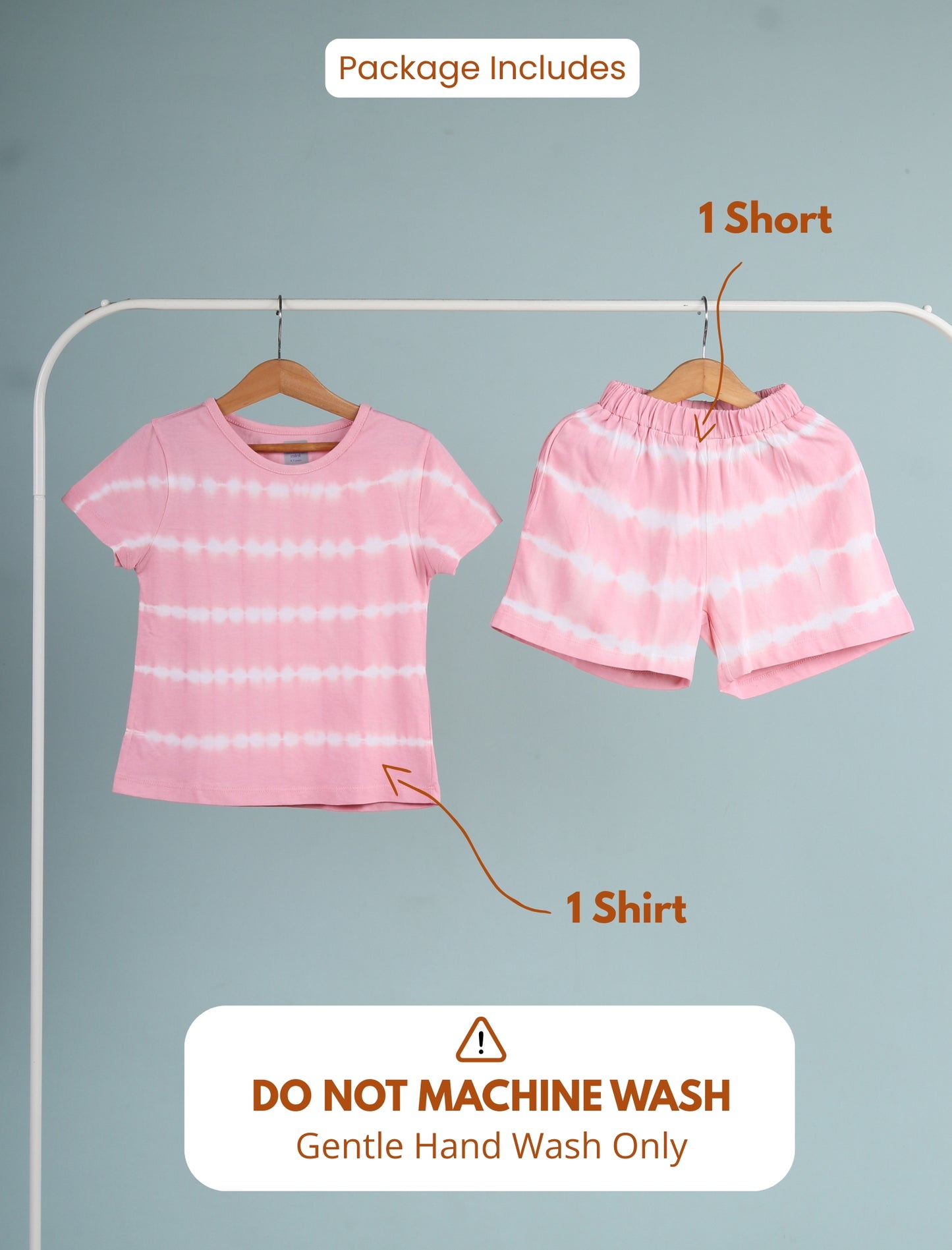 Pink tie-dye shirt and shorts on hangers with washing instructions on a gray background