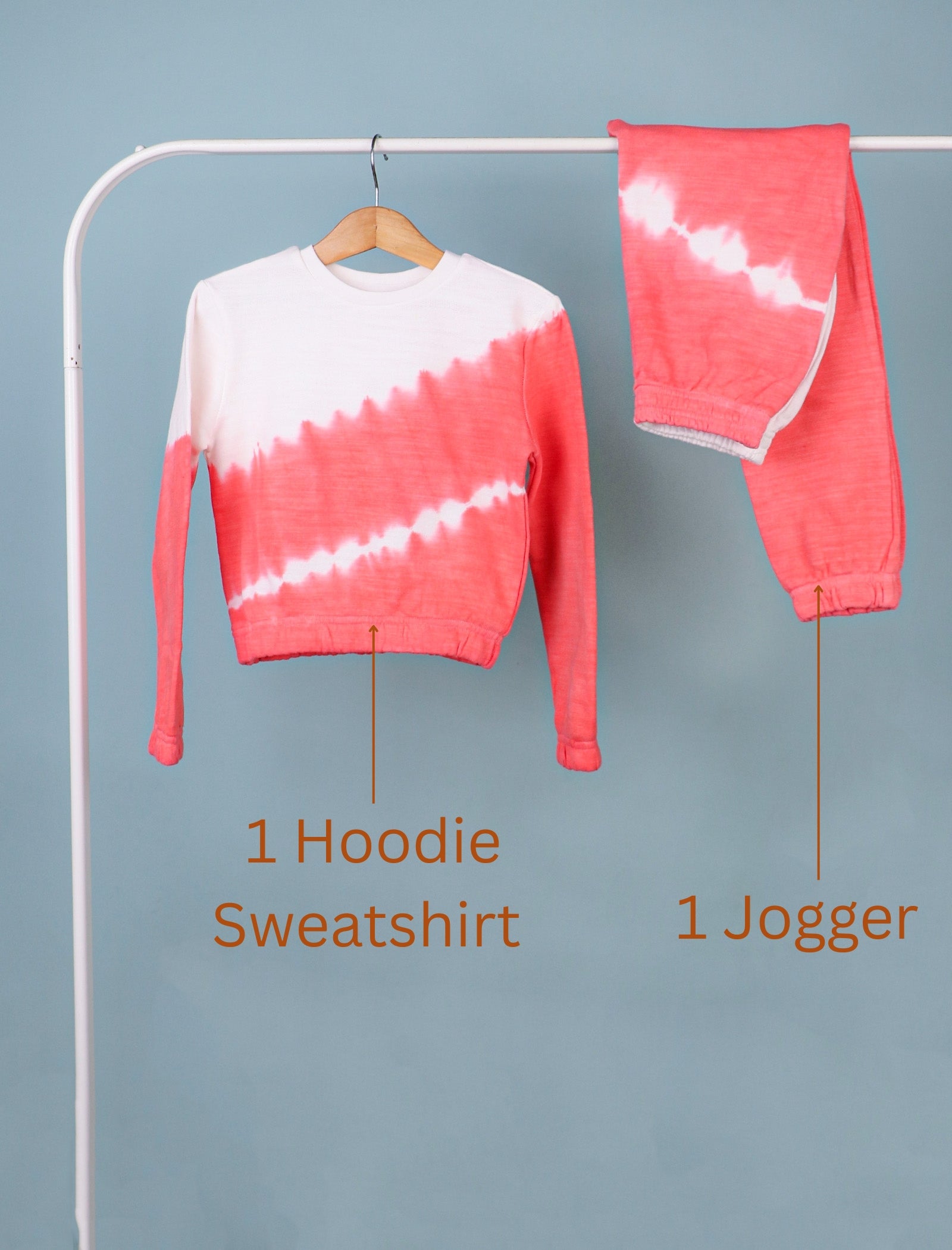 Red and white tie-dye hoodie sweatshirt and jogger on a rack against a gray background