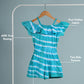 Teal and white striped romper on a hanger with text labels on a gray background