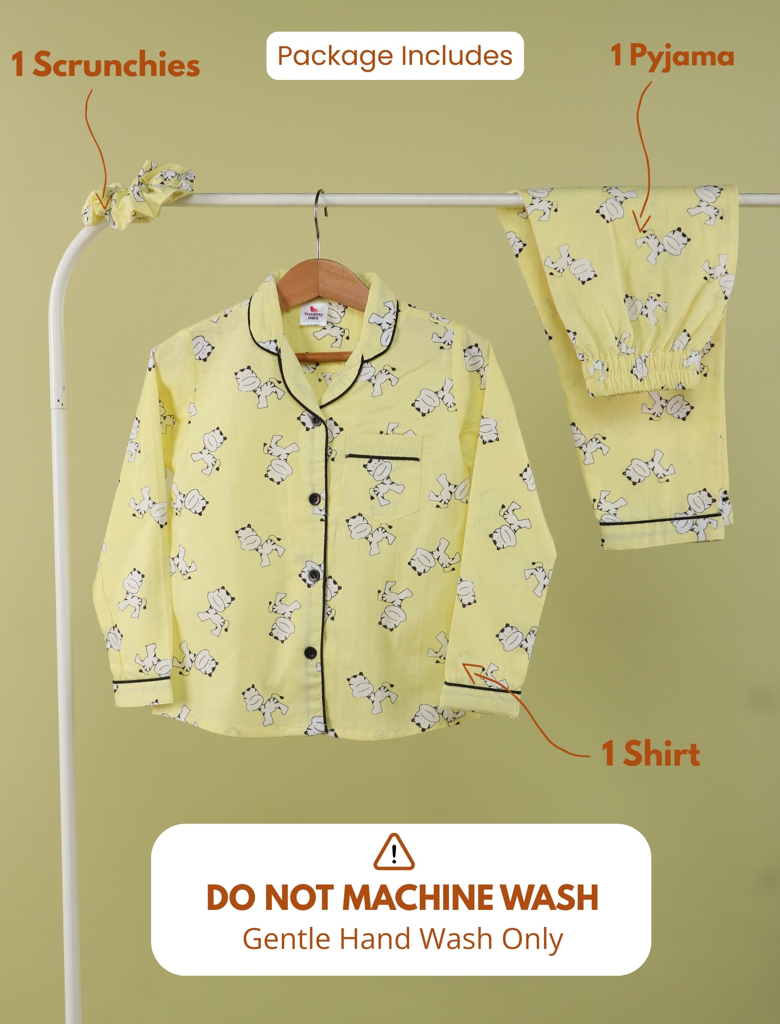 Yellow pajama set with scrunchies on a hanger against a green background
