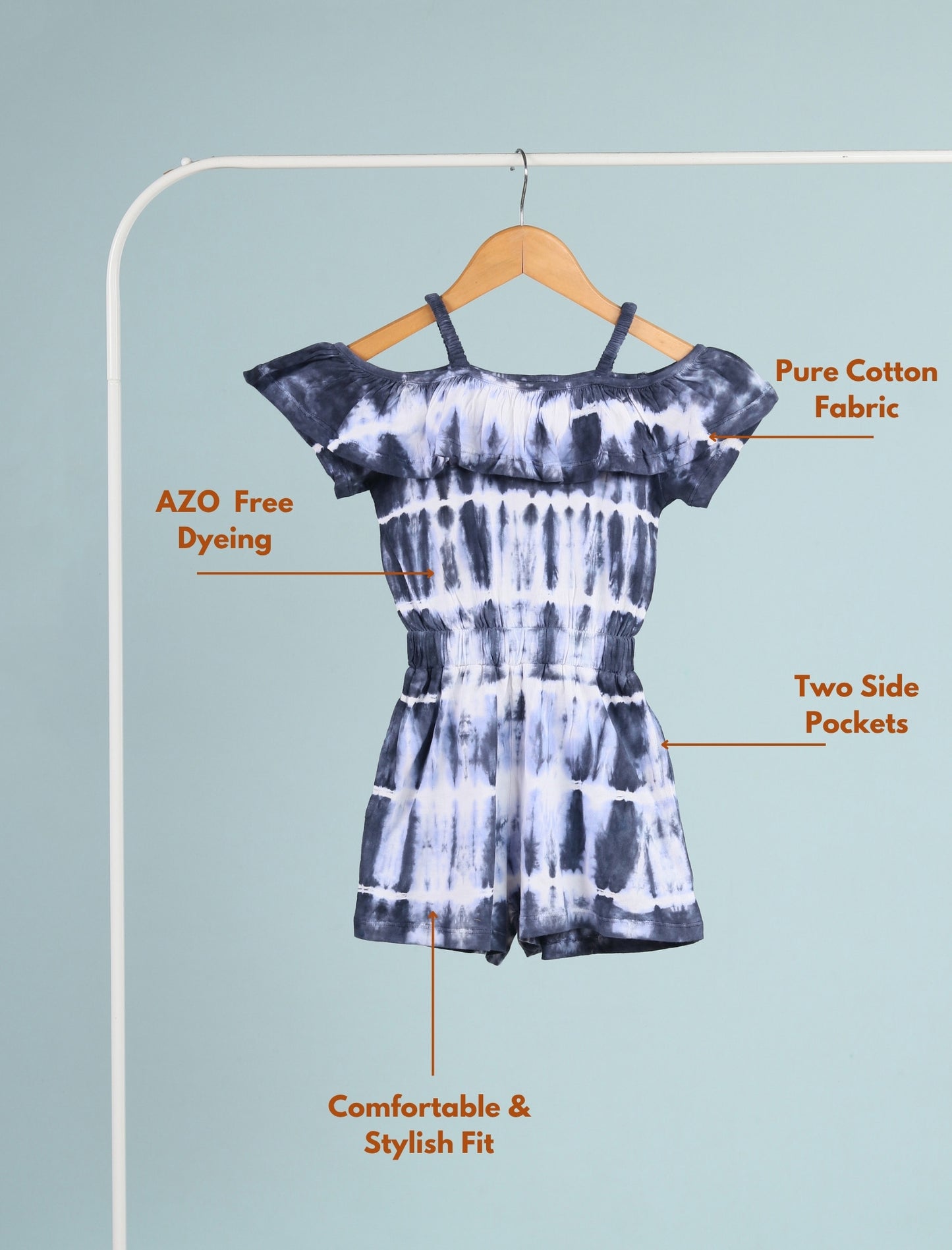 Tie-dye romper on a hanger with text highlighting features against a light blue background