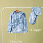 Blue tie-dye hoodie and jogger pants on a rack against a green background