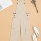Beige overalls on a beige background with white sneakers and a newspaper.