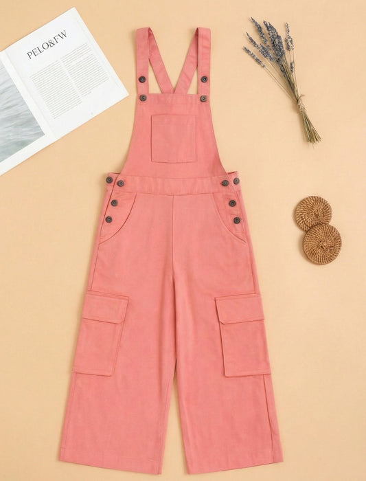 Peach denim overalls on a beige background with a magazine and decorative items.