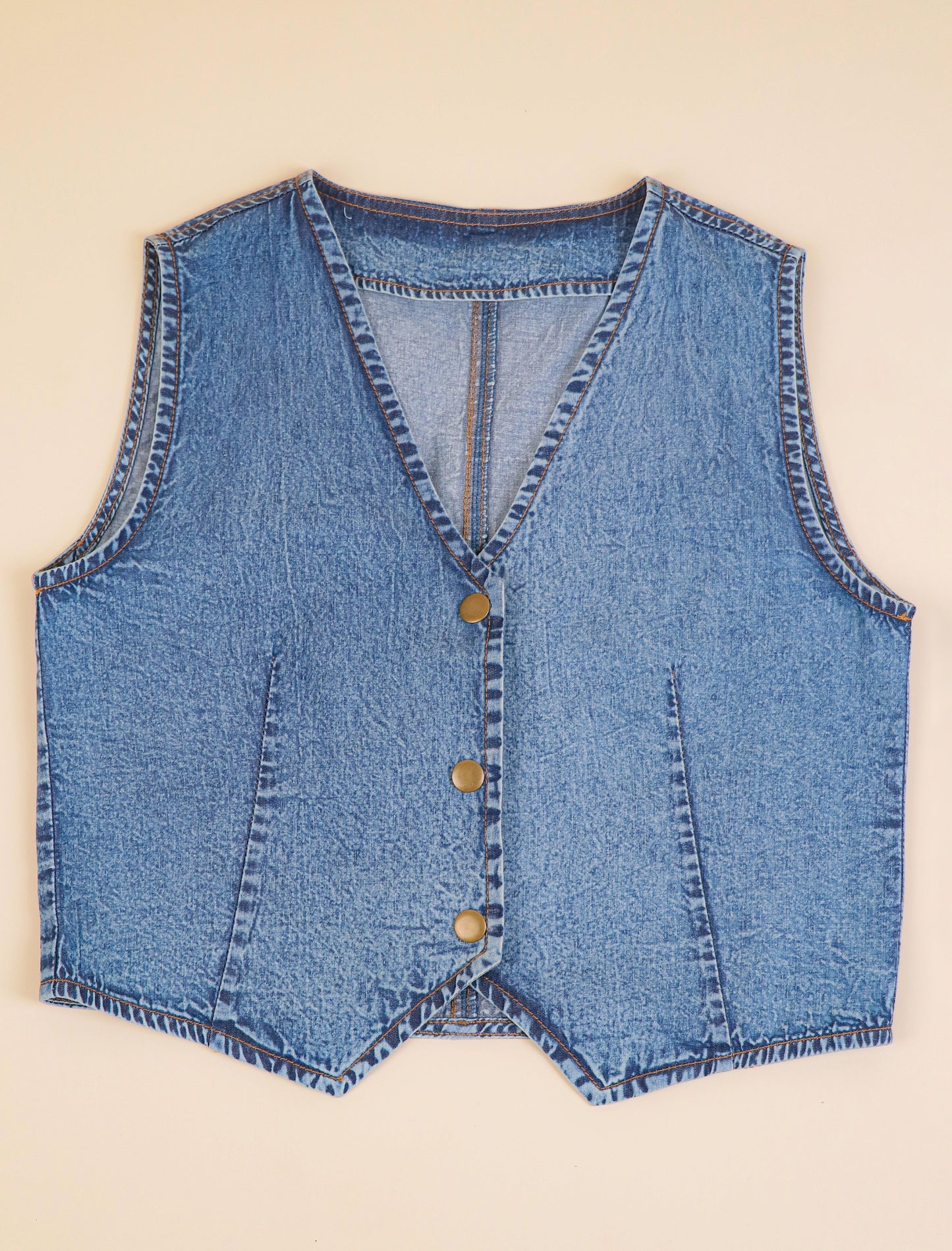 Blue denim vest on a beige background