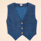 Blue vest with buttons on a beige background
