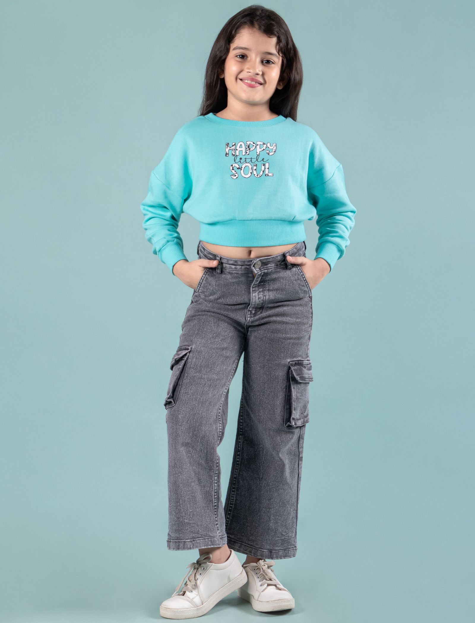 Kids wearing a turquoise winter sweatshirt and gray cargo pants on a light blue background