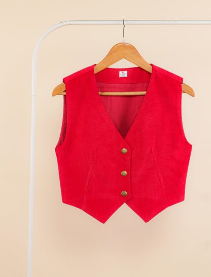 Red vest on a hanger against a beige background