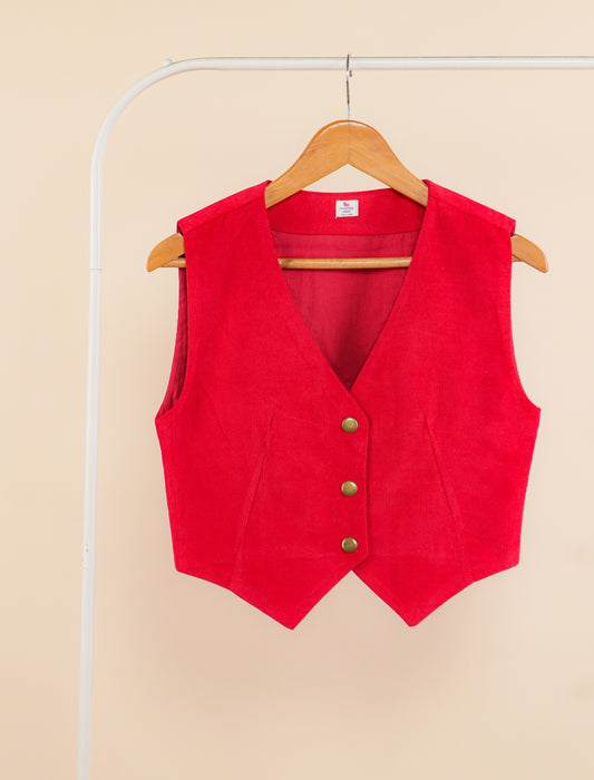 Red vest on a hanger against a beige background