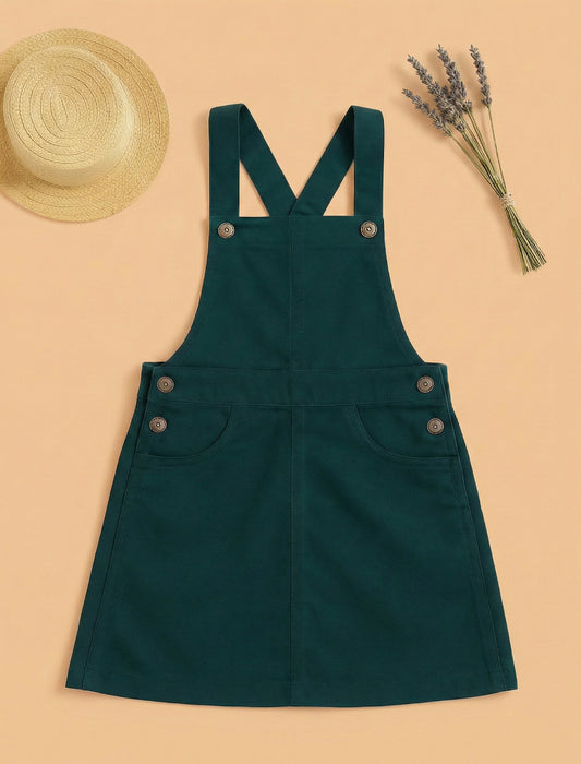 Green denim pinafore dress with a straw hat and lavender on a beige background
