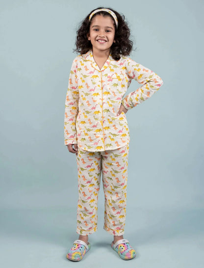 Girl wearing dinosaur print pajama set and headband, kids sleepwear fashion.