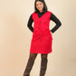 Girls wearing a red dress over a black shirt with brown knee-high boots on a beige background