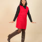 Girls wearing a red dress with a black top and brown knee-high boots on a beige background