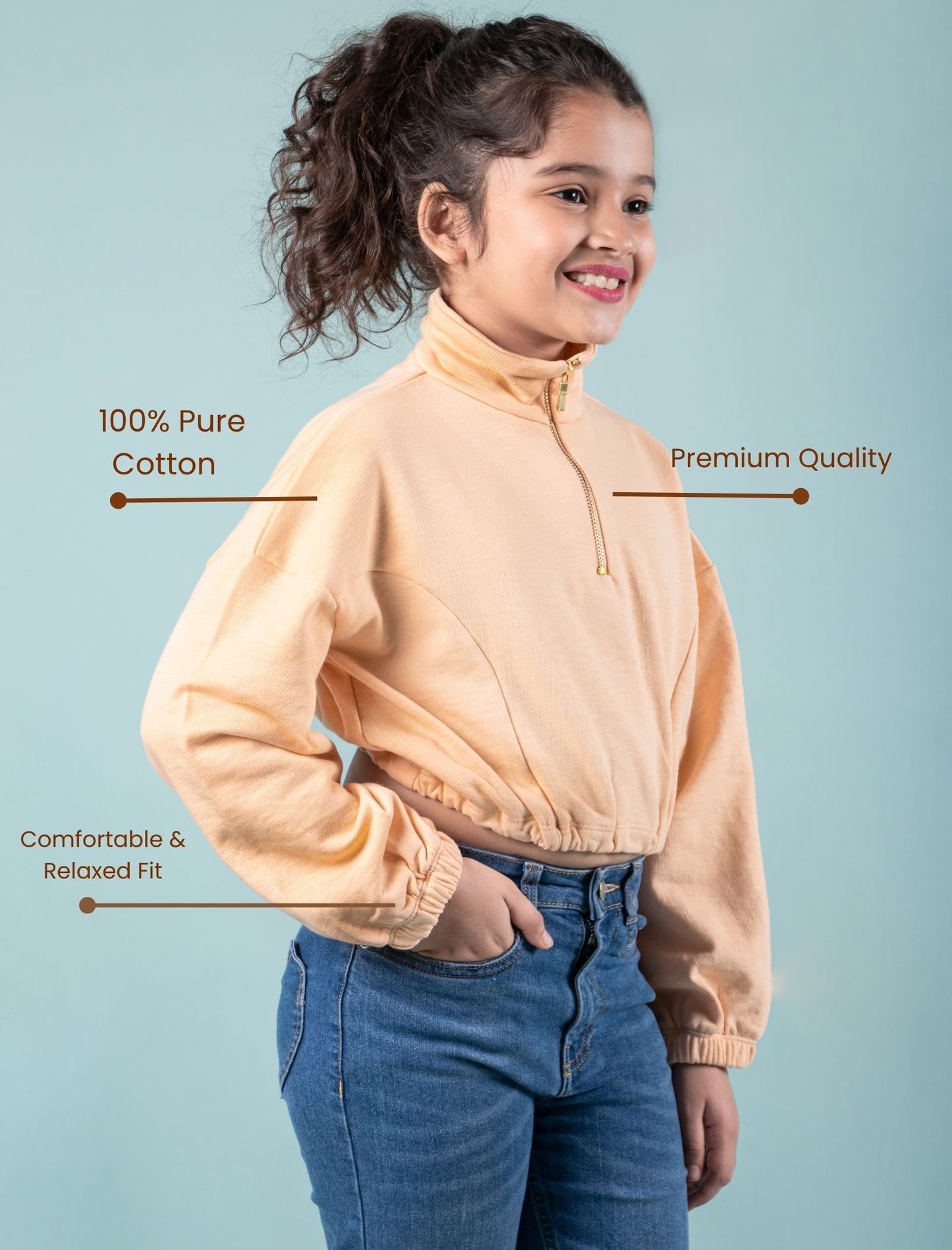 zippered sweatshirt for girls wearing a peach jacket with text highlighting features on a light blue background